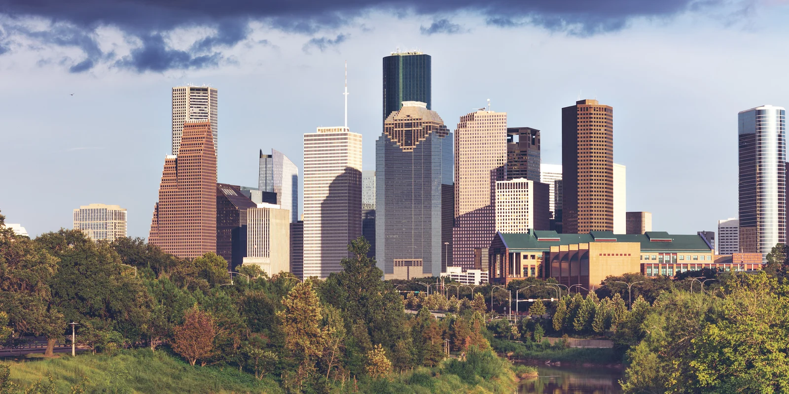Downtown Houston skyline above the trees and water of Buffalo Bayou
